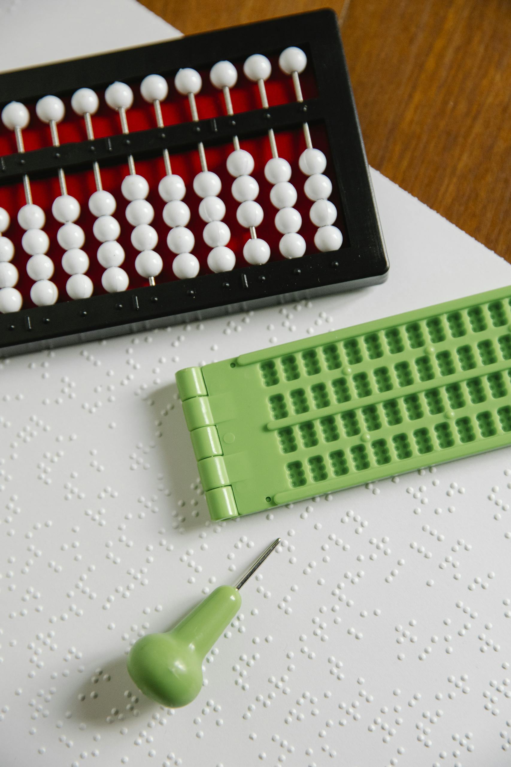 Abacus and Braille tools on a textured surface, perfect for inclusive education themes.