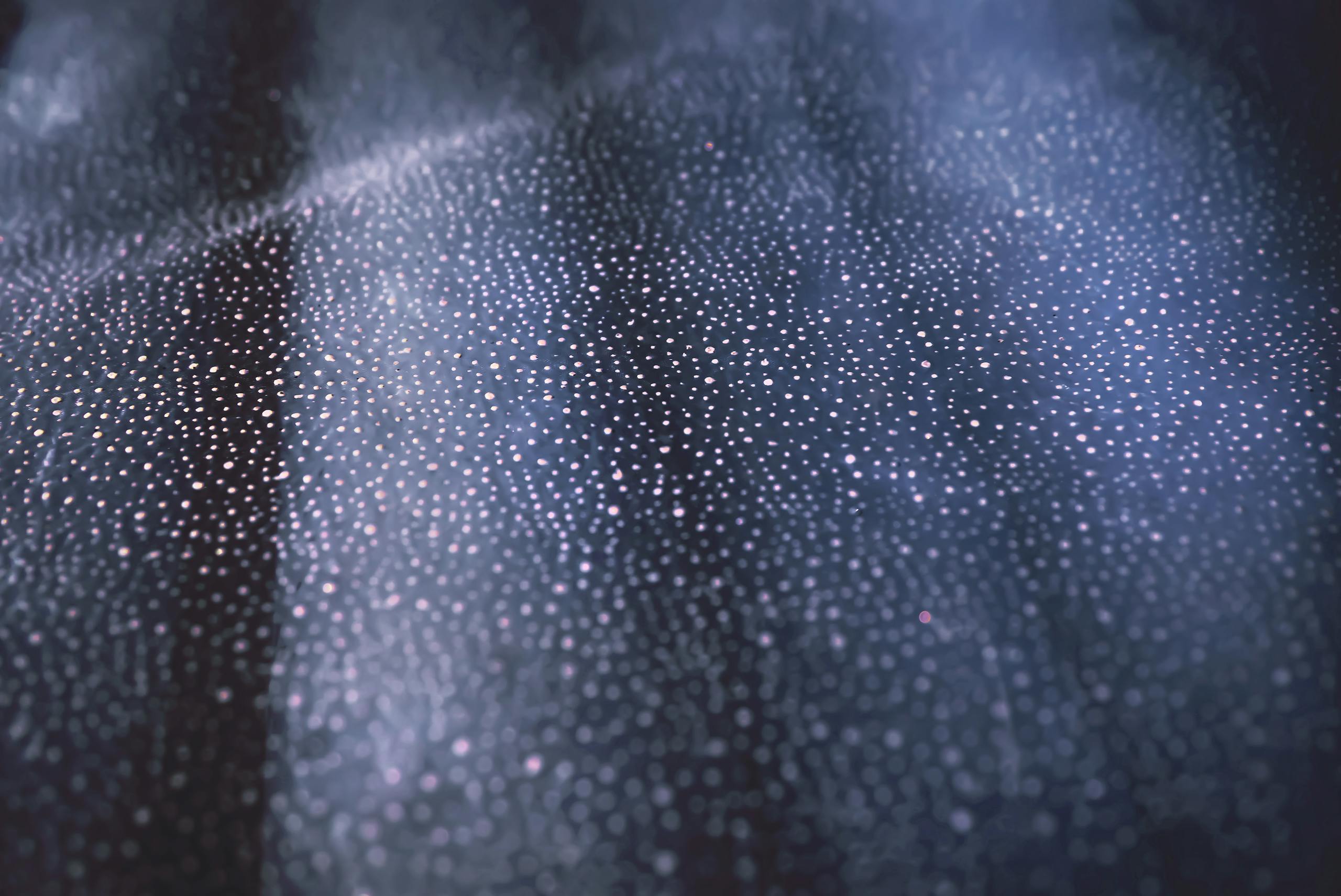 Close-up of shimmering bokeh lights on a textured dark surface creating an abstract pattern.