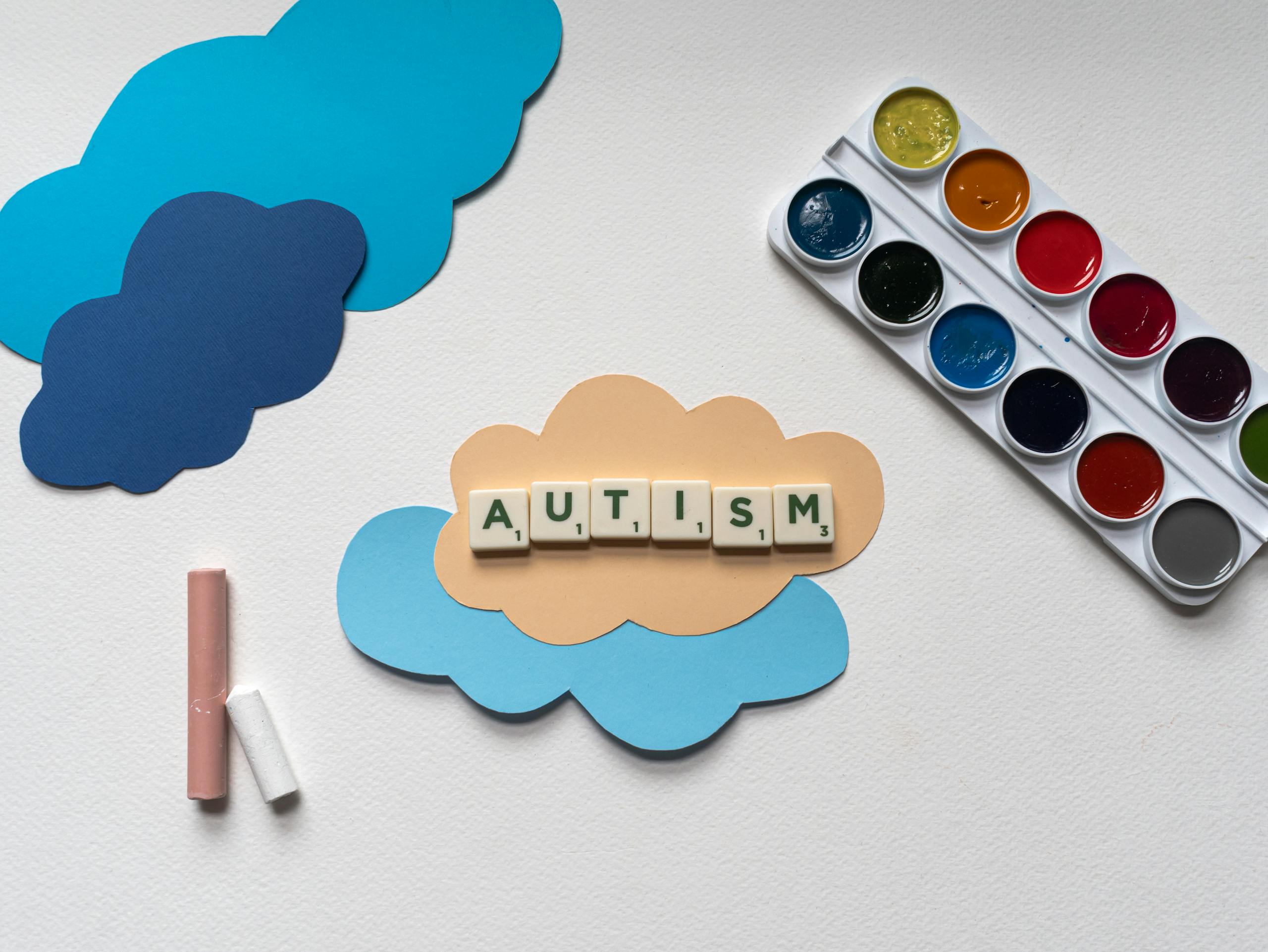 Colorful photo highlighting autism awareness with paper clouds and watercolor paints.